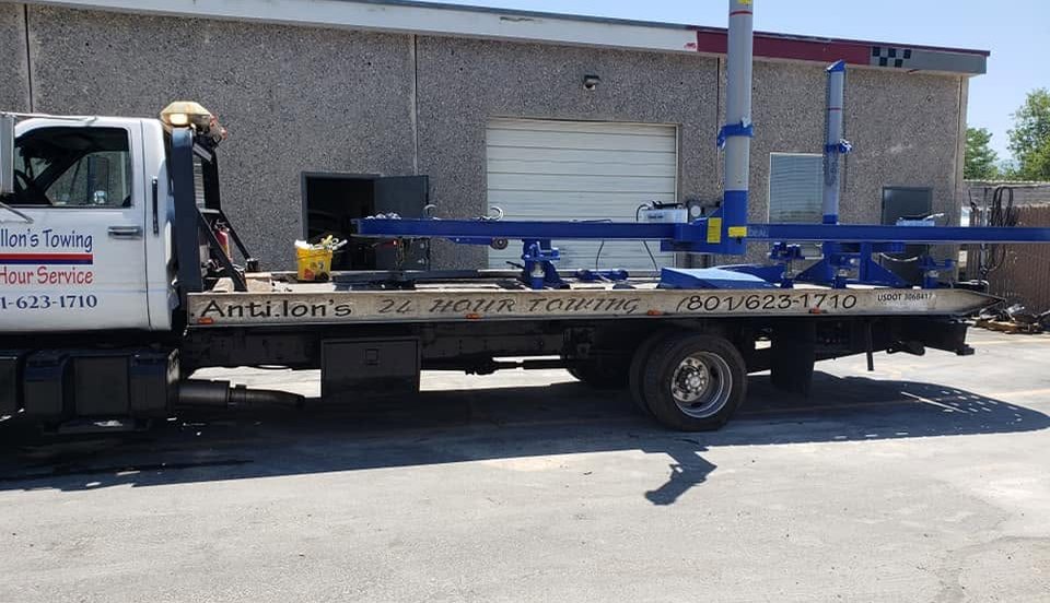 Automotive lift equipment loaded on an Antillon's flatbed outside a shop