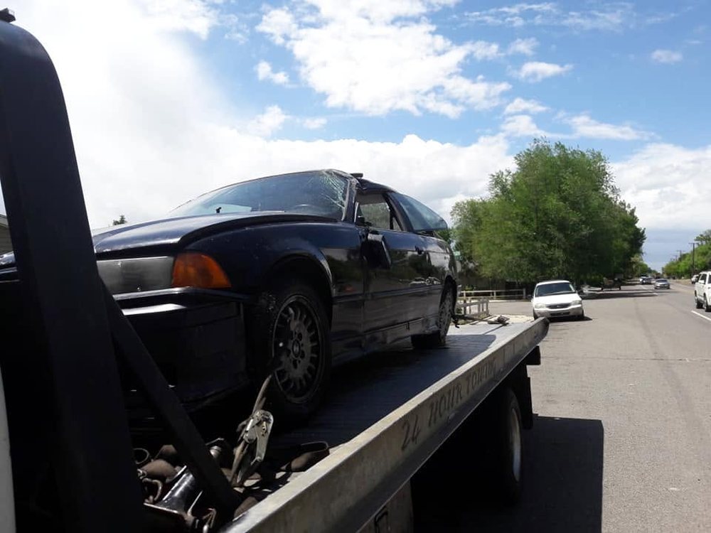 Collision-damaged car strapped down on an Antillon's flatbed